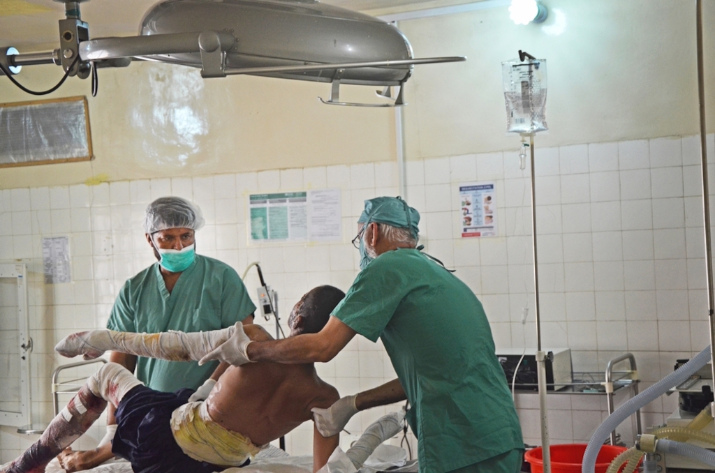 Operating theatre staff prepare a 20-year-old man for surgery at the MSF-supported hospital s in Boost, Lashkar Gah, Afghanistan. The man suffered extensive burns to his face and arms after being involved in a bus crash on a motorway. Photographer: Kate Stegeman/MSF