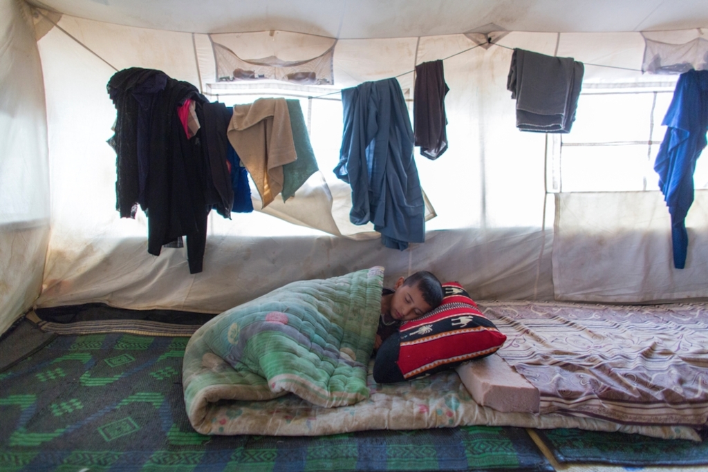 A young boy sleeps in his family's tent in Khanaqin refugee camp in northern Iraq. In the camp, MSF provides mental healthcare, treatment for non-communicable diseases and health promotion activities for people displaced by violence in neighbouring regions. Photographer: Ton Koene