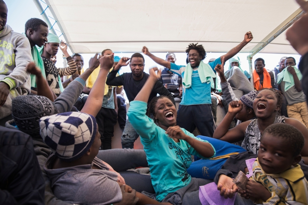 On board MSF's search and rescue ship Dignity I, people celebrate their rescue from a boat in distress. Some 435 people were rescued, most of them from Guinea, Mali, Ivory Coast and Senegal. Photographer: Anna Surinyach/MSF