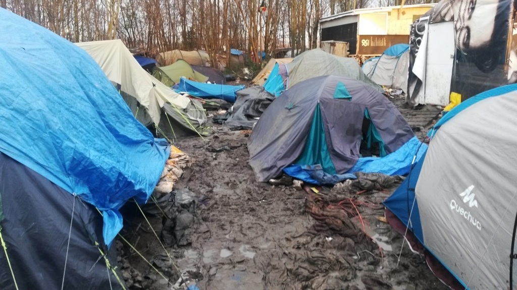 Photographer: Sophie-Jane Madden<br/><br/>Caption: Refugees in the Gramde Synthe refugee camp near Dunkirk, France, contend with deplorably bad conditons in the camp with mud, flooding and a lack of sanitation. Authorities have imposed a ban on humanitarian agencies bring in any building materials or any extra comfort items such as blankets despite the desparate conditions and deteriorating health of the inhabitants.