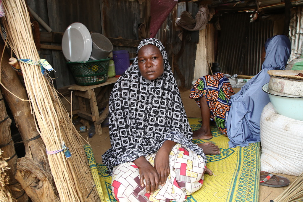 A woman displaced by the conflict between Boko Haram and the Nigerian armed forces sits in her tent at a camp in the town of Banisheikh, in the northeastern state of Borno. Photographer: Igor Barbero