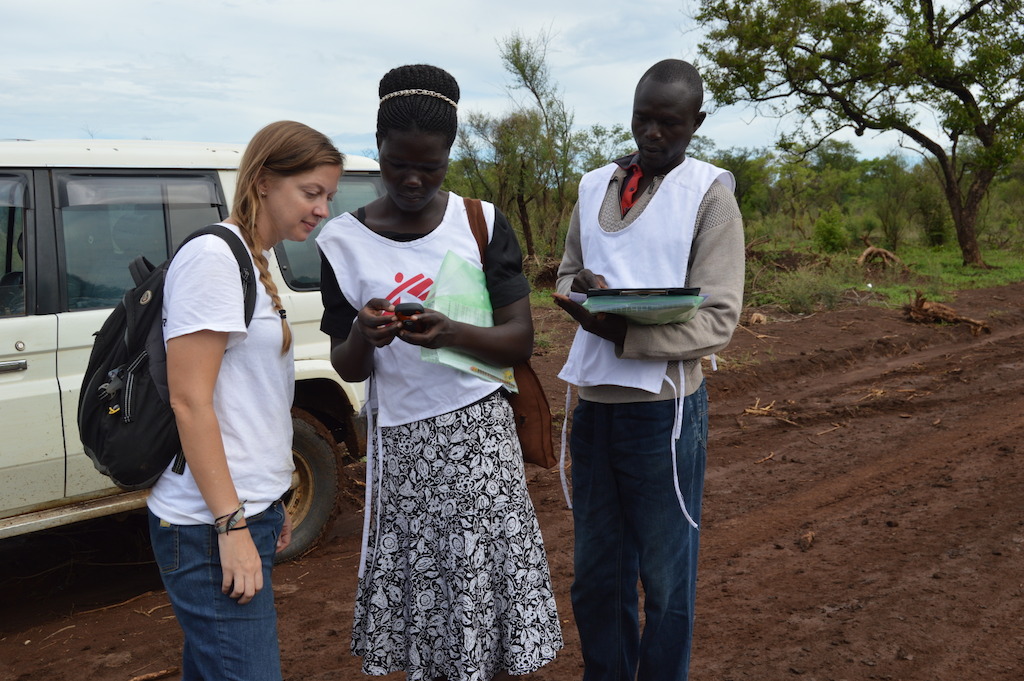 MSF staff members pause on the road to look at the location of a sample household in Palorinya refugee settlement, northern Uganda. <br/>MSF runs a health surveillance system in Palorinya to monitor and detect changes within the population and to help inform its medical and humanitarian interventions. <br/>Quotes from Sam Hoare, a public health physician who recently returned from Uganda where he was working on an emergency health surveillance system in Palorinya: “We also use the information and data to advocate for more services from other organisations that can support the refugee population with things like latrines or hand washing facilities.<br/>The team collects information about births, deaths and ill health from individuals through weekly household interviews, while also collecting medical data from health facilities in and around the settlement. Household interviews are a really important part of our data collection work, as we can build a better understanding of peoples lived experiences and needs, rather than only being exposed to those who are able to visit health facilities. <br/>In acute emergencies like this, when large communities are in chaotic new environments and new countries, it can be very difficult to understand their health status, making the population particularly susceptible to epidemics and diseases. Outbreaks of infectious diseases are common; in addition, the rainy season increases outbreaks of diseases like malaria, and often hinders access to health services. A functioning health surveillance system helps us detect changes in the health of the population, meaning we can respond to identified needs.<br/>We have trained a team of over 100 surveillance officers from within the refugee settlement in the hope that they are more familiar with local customs, language and culture, and can collect more accurate information on sensitive topics such as deaths. We use this data to inform medical activities, and project trends such as birth and death rates across. Photographer: Yuno Cho