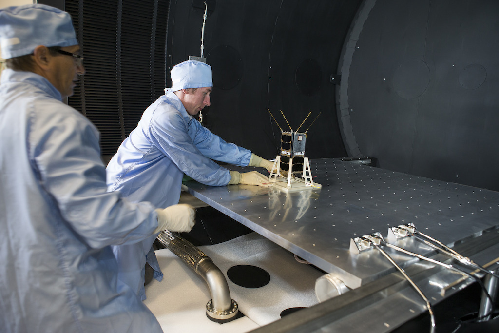Mike Petrovic (L) and Bart Fordham from ANU load a CubeSat into the space simulator at the ANU Advanced Instrumentation and Technology Centre. Image: Stuart Hay, ANU.