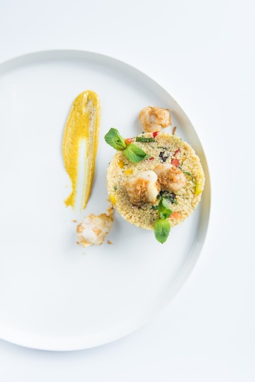 Jans café - quinoa-couscous salade met crispy roggewangetjes, met gemengde paprika, rozijnen en munt en een currydressing.