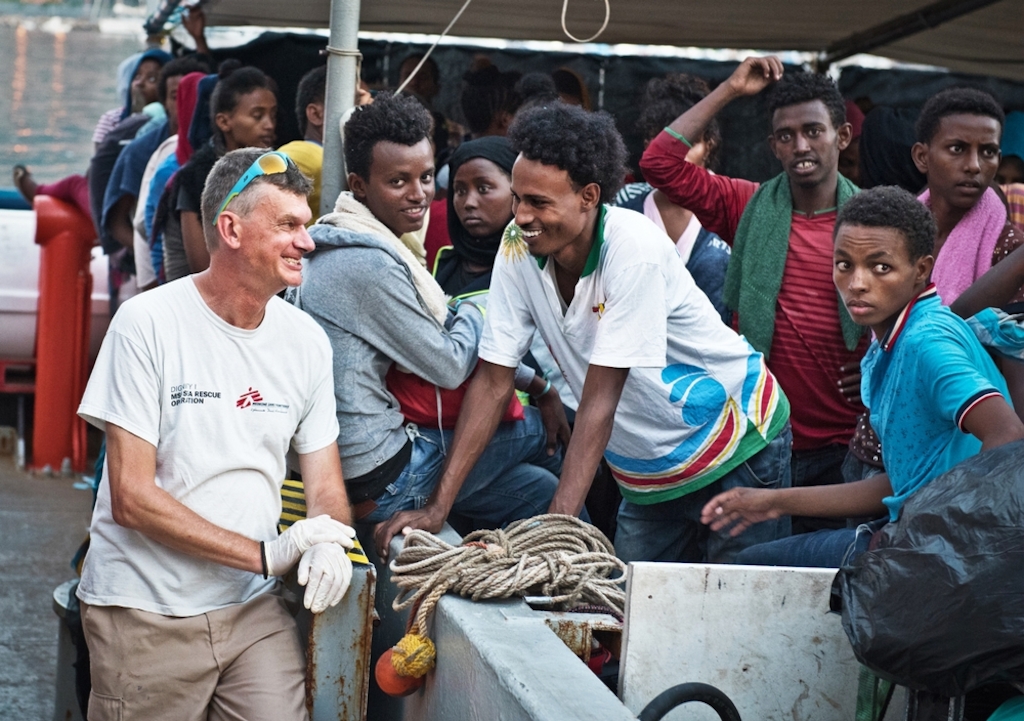 MSF doctor Pierre Vachaud shares a joke with a young man from Eritrea aboard an MSF search and rescue ship as the crew prepare to land on the coast of Italy. Photographer: Sara Creta