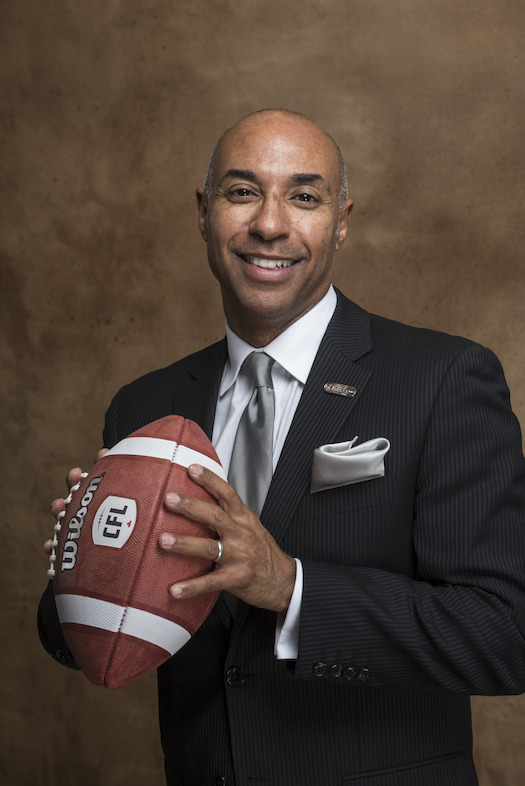 Commissioner Jeffrey L. Orridge with an official game ball displaying the CFL's new logo