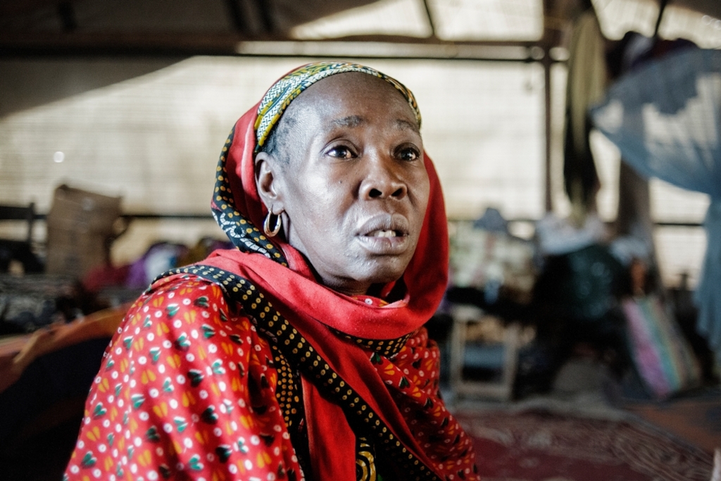 MSF159643<br/>Portrait of 45 year old Alima at the at a camp for displaced persons at the Central Mosque in Bangui.<br/><br/>Alima and her family lived at the Miskin market in Bangui before the violence. One day an armed group surrounded the neighbourhood and killed people. After this, she fled with her family (4 boys, 3 girls and her little brother) to find safety at the Central Mosque of Bangui in PK5. After having stayed in the camp for a few days, her little brother wanted to return to their home to get some papers that he had not been able to take during their escape. When he arrived back home he was killed by a group of armed men. "My little brother said: I am not a Seleka! But the attackers said he was a Muslim, which was enough to kill him”. <br/><br/>Alima has never been able to retrieve the body of her little brother. Alima now lives in the Central Mosque in difficult conditions. She says she lost one of her sons who became sick due to the living conditions in the camp. Despite receiving treatment by the Red Cross. Alima is trying to cope by relying on the help of other people living with her in the camp, as she and her husband are unemployed. “We were born here, our parents and grandparents too... and now we are treated as strangers". Last week, one of Alima’s sons won a football tournament. The trophy is proudly displayed in their shelter.
