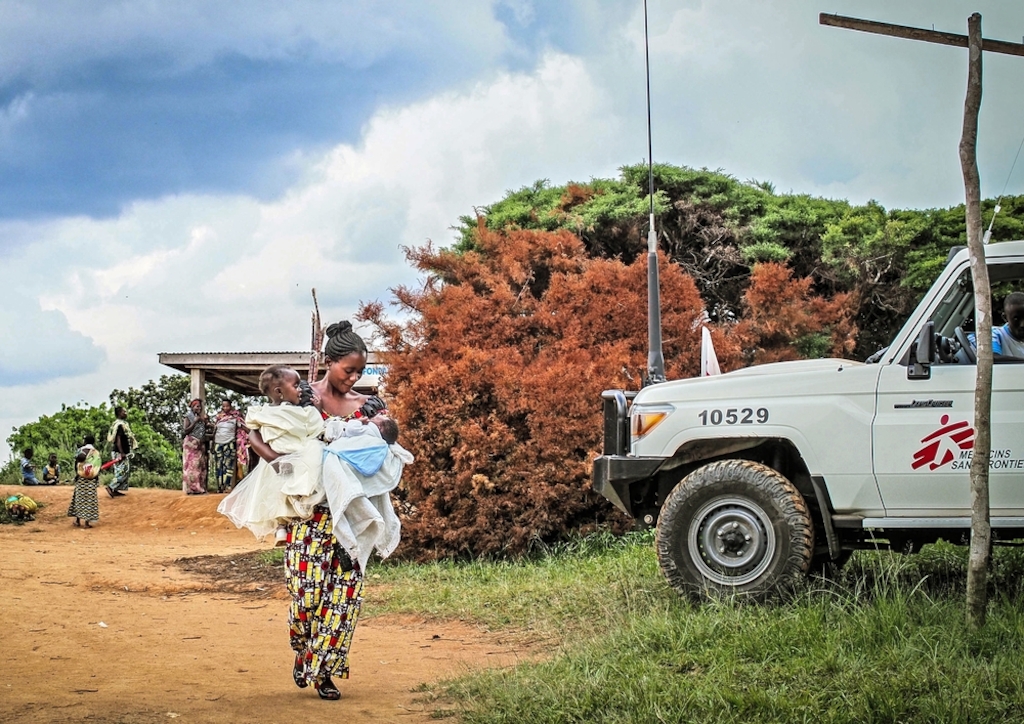 A mother carries her two children to Tchabi health centre to receive polio vaccinations during a community healthcare and health promotion programme run by MSF in Boga, Democratic Republic of Congo. Photographer: Gabrielle Klein/MSF