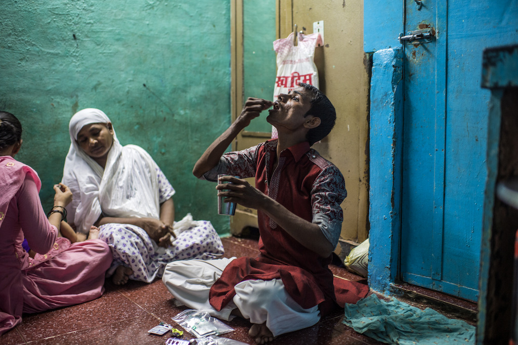 XDR-TB patient Hanif, taking his daily TB medication at home in the Govandi area of Mumbai.<br/><br/>Hanif is 25 years old, lives in Mumbai, and is one of only a handful of extensively drug-resistant TB (XDR-TB) patients in India lucky enough to be able to have acesss to the new drugs. After having failed treatment for the fourth time, Hanif was referred to the clinic of Medecins Sans Frontieres (MSF) / Doctors Without Borders, an international medical humanitarian organisation who since 2006 provides free diagnosis, treatment and support to patients with drug-resistant TB in Mumbai. Photographer: Atul Loke
