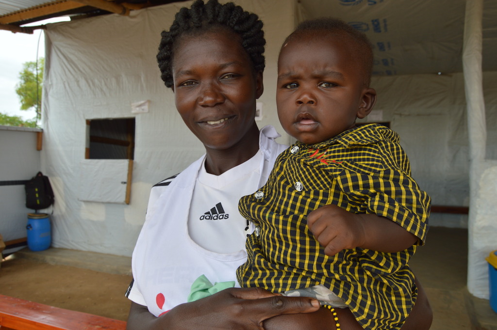 Nola Aniba Tito, 27, is one of the medical translators working in MSF health centre in Ofua 3 zone, in Rhino settlement. Originally from a town in the Equatoria region, she fled violence in South Sudan in July 2016 with her children and started working with MSF in March 2017. As 86% of all South Sudanese refugees in Uganda are women and children, Nola is one of the many female head of households. In this photo she is pictured with her baby, Aaron.<br/>Full testimony from Nola: “I was living with my two children and expecting another child. My husband was in Juba. In my neighborhood, everyone was fleeing because we were seeing child abduction, rape, looting, forced marriage, and killing between tribes almost every day. Schools were attacked and children slaughtered like chicken. If people from the other tribe come, they kill everyone from the other tribe and leave their own tribespeople. Moreover, there was no access to health care, especially after many NGOs left the country.<br/>One day, men knocked on the door of our house and threatened to open it. I was very scared so I didn’t open it, but instead carefully opened the window and saw them holding guns. I cried and shouted so much that neighbors came and the men just left. That’s when I decided to leave my home right away, without any belongings, just with my children and three of my brother’s children, who hasn’t been able to cross into Uganda. Even on the way to Uganda, there is fear of killing and violence and that is why my brother is still in South Sudan.<br/>I was lucky to make it to Uganda. But upon arrival in the camp, we found no water, no food, and no health services. Sometimes we had no water for more than a week. How can we live without any water to use and drink? I also had to walk a very long distance to the hospital outside the camp to deliver my baby, who is now seven months old. We left with nothing, not even a penny to buy food or to pay for transport to hospital. So the start of MSF health service. Photographer: Yuna Cho/MSF
