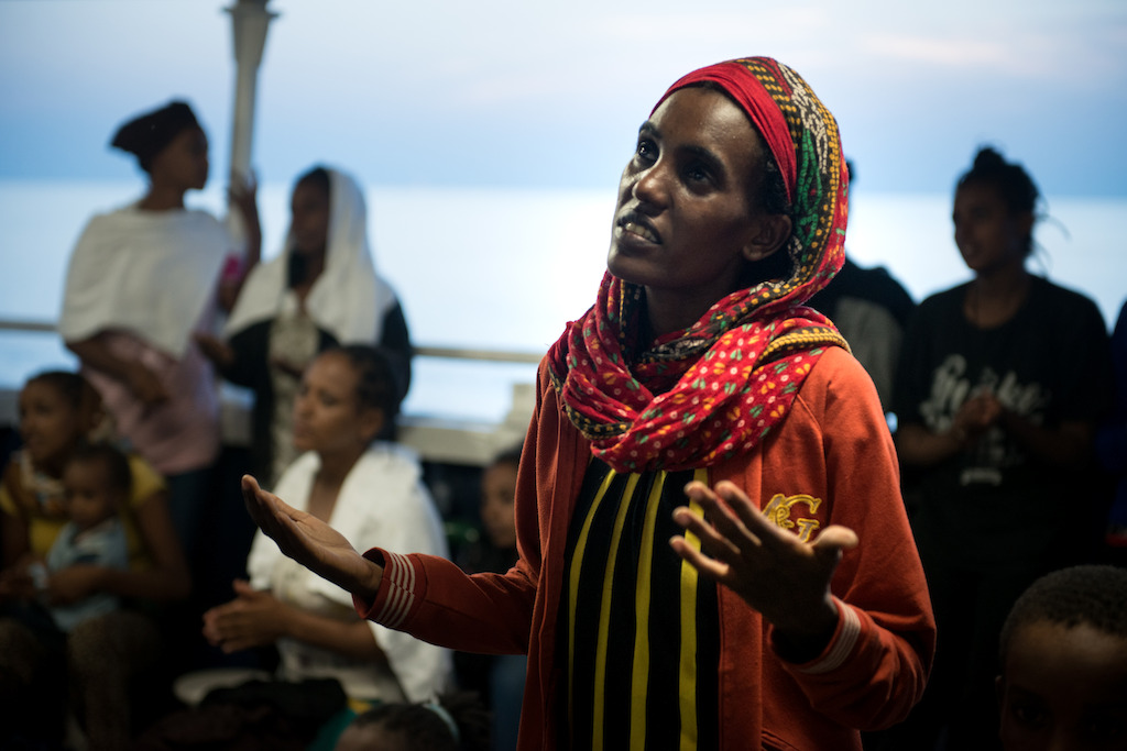 Credit: Gabriele François Casini / MSF<br/>Caption: Phoenix rescue 02 Sept 2015. An Eritrean woman singing a prayer with other women and children after being rescued 02 September 2015 by the MSF MY Phoenix search and rescue vessel at sea.