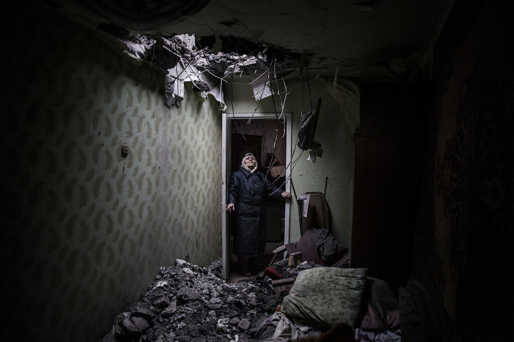 © Manu Brabo<br/>Galina, 86 ans, regarde vers le trou créé par une bombe dans son appartement de Donetsk, à l’est de l’Ukraine. Les équipes de Médecins Sans Frontières ont apporté leur aide des deux côtés de la frontière, jusqu’au début de l’automne 2015 quand elles ont été expulsées par les républiques autoproclamées de Donetsk et Lugansk.