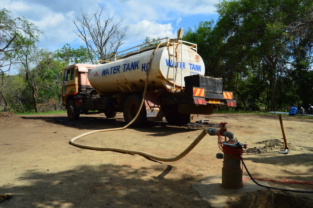 A water truck rented by MSF is shown getting water from the groundwater in Rhino refugee settlement, northern Uganda. MSF produces an average of 2 million litres per day from the Albert Nile River, which is delivered to tanks throughout the settlement by water trucks rented by UNHCR. Bad road conditions make it difficult for trucks to access the whole camp after heavy rains, leaving several areas vulnerable to water shortage. Access to water is one of the biggest challenges in Rhino settlement. To reach certain areas, water trucks have to drive more than one-and-a-half hours one way, which during the rainy season may be delayed or made entirely impossible. On average in April 2017, the refugee population in Ofua zones received around 4.6 litres per person per day. MSF is working to improve the sustainability of the water delivery system by improving boreholes to bring the water source closer to the settlement. As of May 2017, MSF (OCP and OCA) is working in 4 refugee settlements, Bidi Bidi, Imvepi, Palorinya and Rhino; providing inpatient and outpatient care, maternity care, nutrition programme, and water and sanitation provision.<br/>By 5 May 2017, there were over 901,755 South Sudanese refugees in Uganda, with the number expected to rise to nearly one million by the end of the year. Some 86% of the South Sudanese refugees in Uganda are women and children under 18, and an average 2,000 new refugees arrive each week. Uganda is now the largest hosting country for South Sudanese refugees, and also the country hosting the largest population of refugees in Africa. Photographer: Yuna Cho/MSF