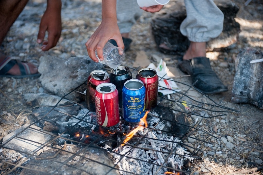Photographer: Georgios Makkas<br/><br/>Caption: Syrian refugees use empty cans to boil water make tea in Kara Tepe camp.