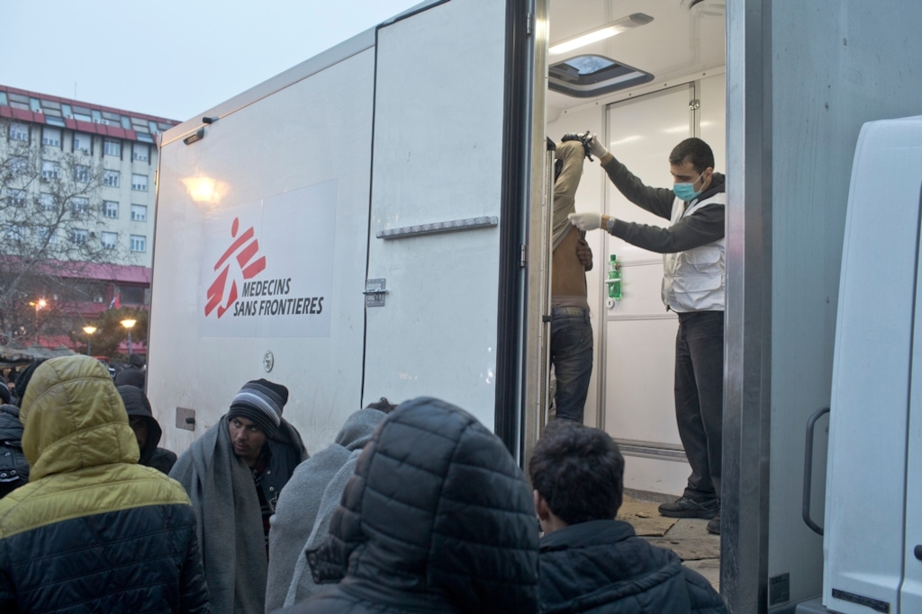Gassem Kazemi, a Medecins Sans Frontieres (MSF) staffer, inspects a patient for scabies inside an MSF mobile clinic in Belgrade, Serbia. Photographer: Marko Drobnjakovic