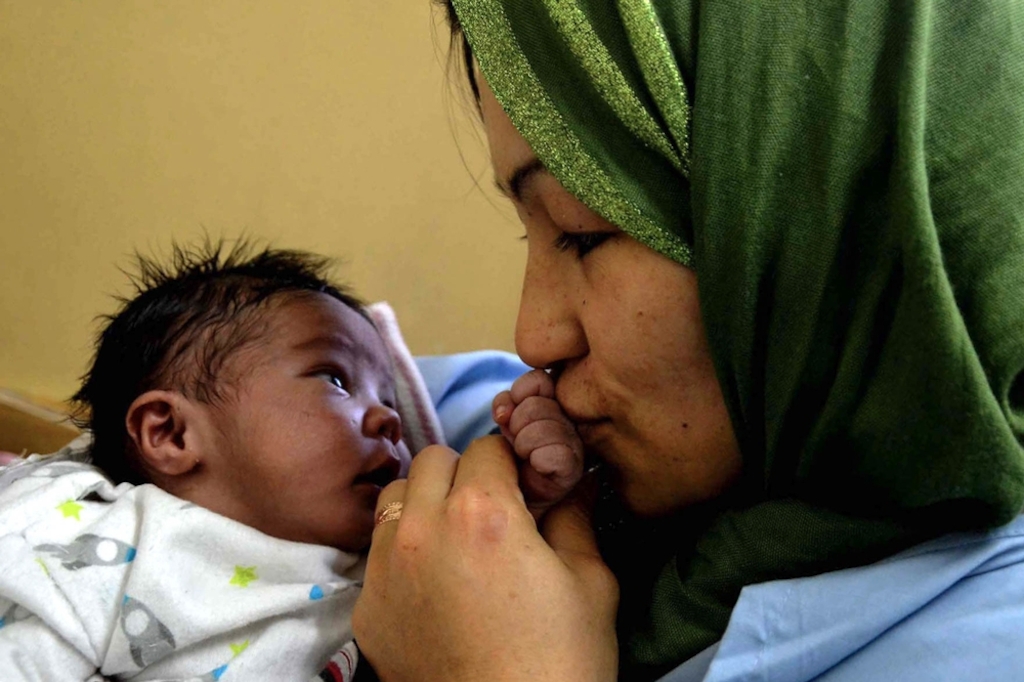 A proud, happy mother kisses her baby’s hand in Dasht-e-Barchi’s New Born Unit. Photographer: Kate Stegeman/MSF