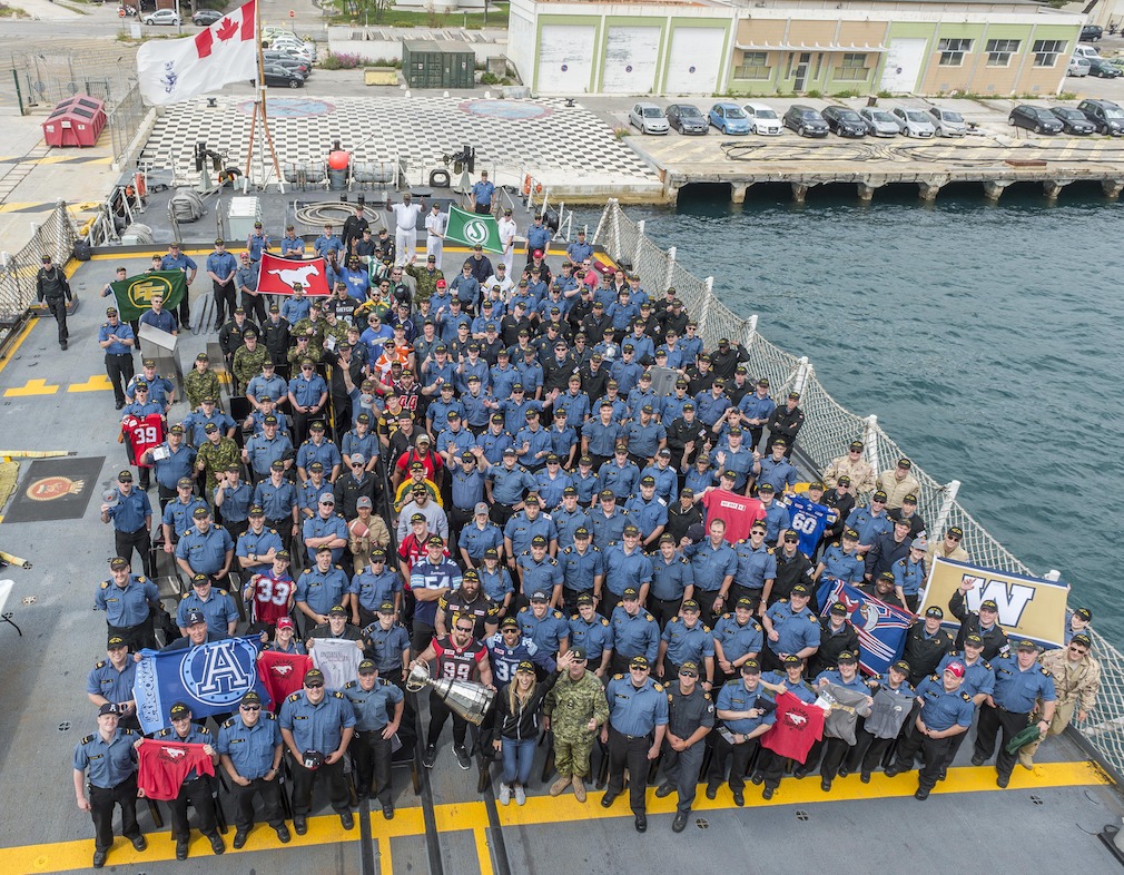 Des joueurs de la LCF et des membres des Forces canadiennes à bord du NCSM St-John's à Marseille, en France.