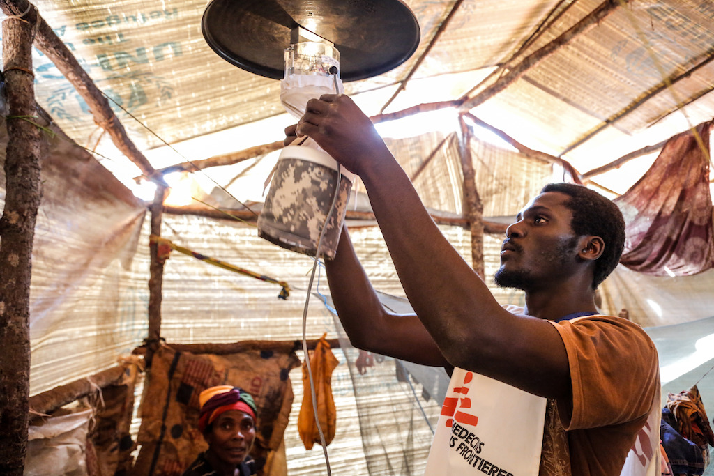 A member of the “mosquito team” (vector control team) installs a mosquito trap inside a shelter. This will help identify the type of mosquitoes that are transmitting malaria in the camp. Photographer: Louise Annaud/MSF