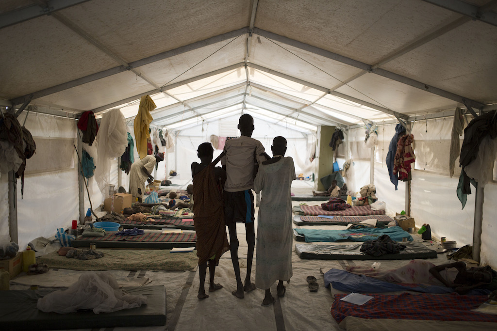 © Karel Prinsloo<br/>Deux membres de sa famille emportent Ruai Puot Malow, 56 ans, à l’hôpital de Médecins Sans Frontières à Lankien, au Sud-Soudan. La violence qui ne cesse de continuer dans ce pays affecte les soins de santé. En conséquence, des maladies telles que le kala-azar, dont souffre Ruai Puot Malow, ont encore fait plus de victimes.