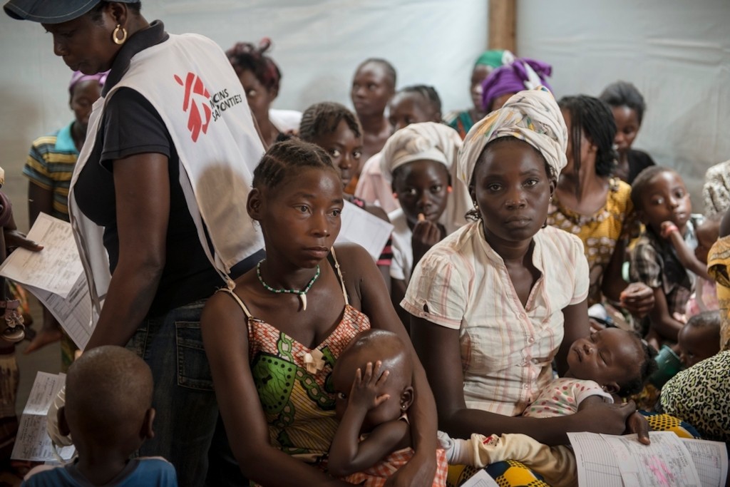 Patient and MSF staff at MSF health post in Mpoko IDP camp at Bangui International Airport. Photographer: Yann Libessart/MSF