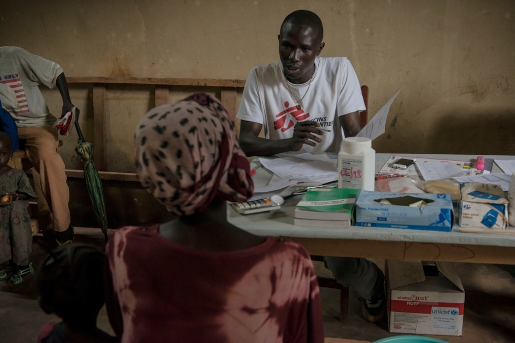 MSF staff with patient at MSF health post in Mpoko IDP camp at Bangui International Airport. Photographer: Yann Libessart/MSF