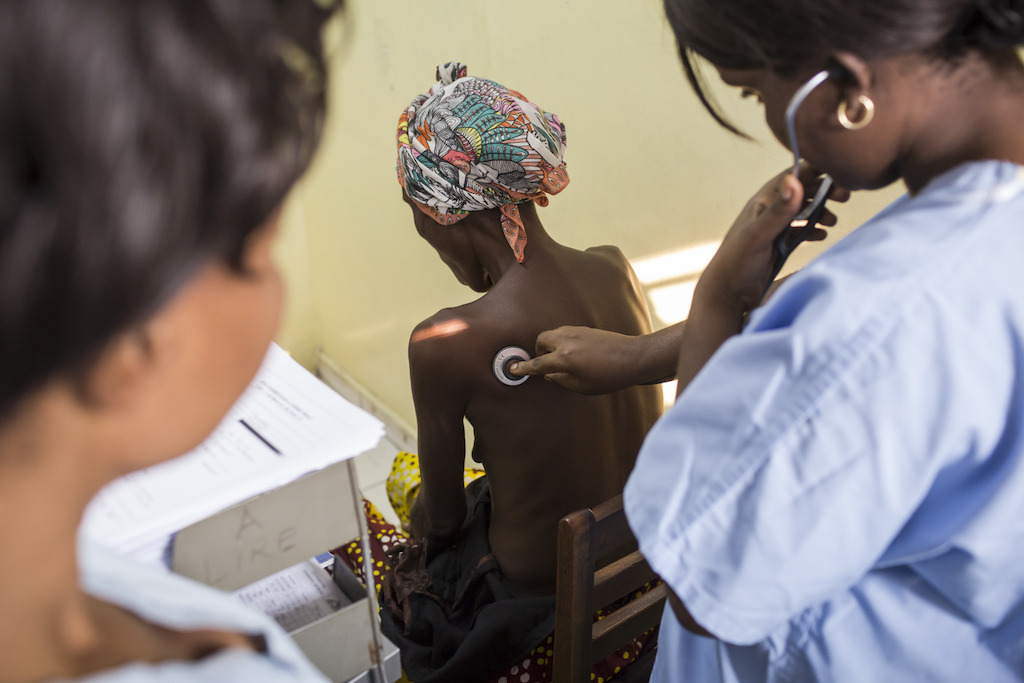 Kinshasa, Democratic Republic of Congo (DRC): An MSF doctor osculates a patient’s lungs to check for abnormalities in MSF’s HIV unit, which provides the only free hospital care for AIDS in the country. In DRC, HIV affects under 2% of the population and is highly stigmatized. People living with HIV also face frequent stock outs of drugs and high costs of tests and treatment. Photographer: Kris Pannecoucke