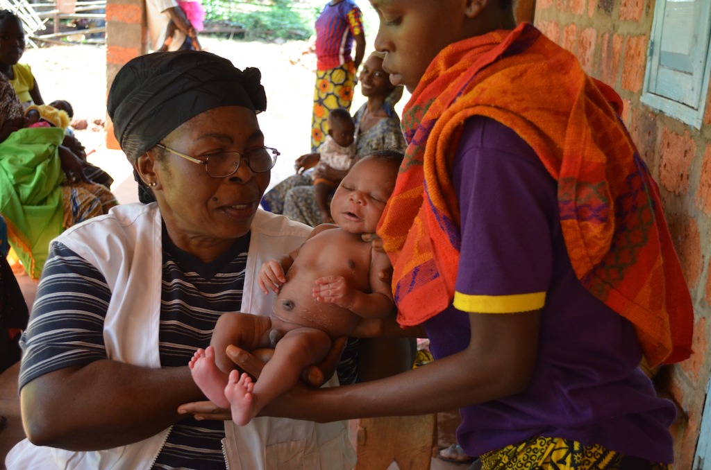 A midwife in Mbalazime health centre weighs a newborn baby during a post-natal checkup. Mbalazime is one of three health centres supported by the MSF team in Bangassou, Mbomou prefecture, CAR. Between January and June 2016, 296 women gave birth safely in these three structures. Photographer: Sandra Smiley/MSF