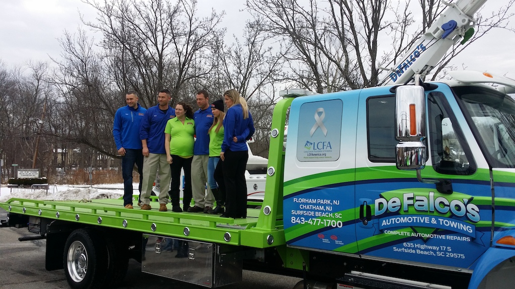 The Rempfer family on the tow truck with Lung Cancer Foundation of America signage
