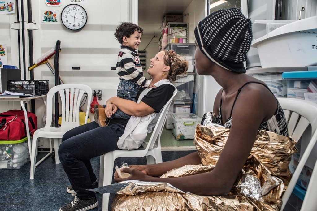 Photographer: Francesco Zizola<br/><br/>Caption: Doctors Without Borders (MSF) nurse Line Lootens entertains a small child on board the Bourbon Argos following a rescue in the Mediterranean The refugees will be taken to Italy.
