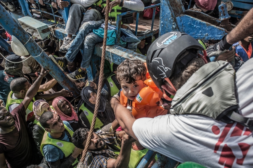 Photographer: Francesco Zizola<br/><br/>Caption: 26th August 2015. A young child is lifted from a boat containing approximately 650 people by Sebastian Stein (Doctors Without Borders / MSF Coordinator) during a rescue in the Mediterranean Sea