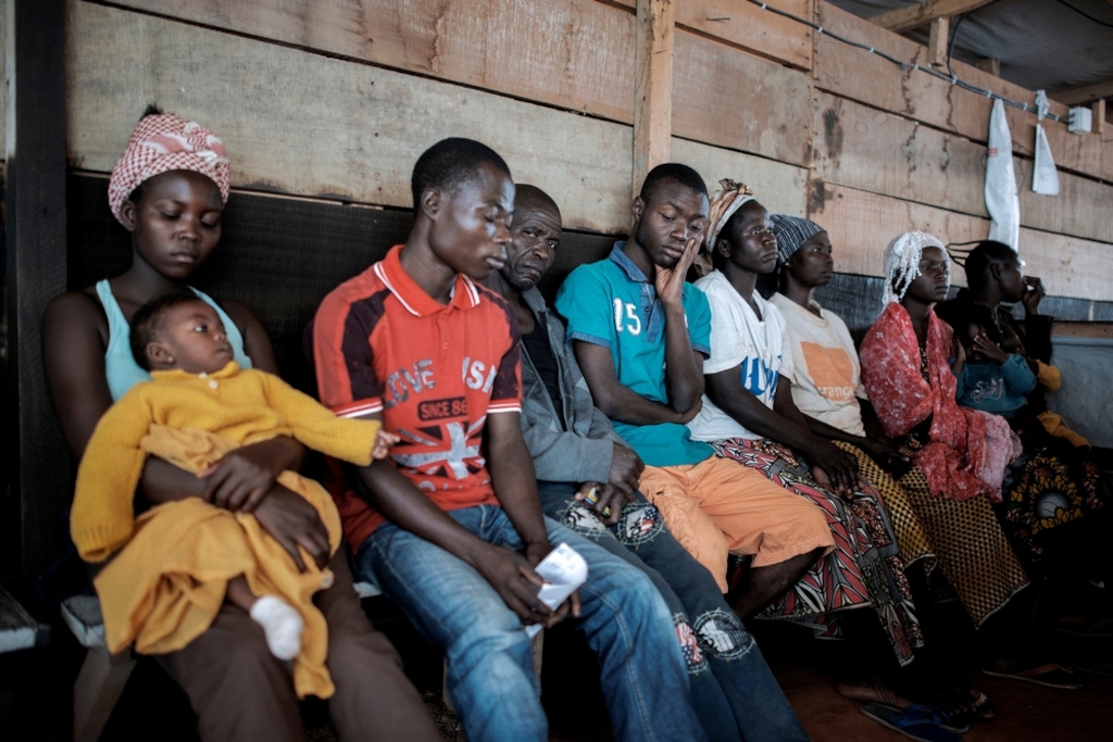 People wait to be seen at a Medecins Sans Frontiers (MSF) hospital at a displaced person camp in M'Poko, Bangui. Photographer: Luca Sola