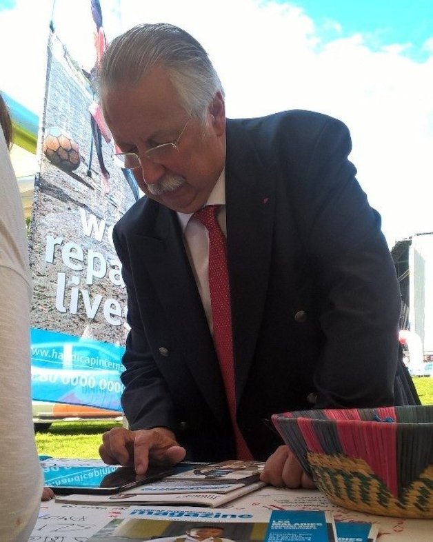 André Flahaut signe la pétiton 'Stop aux bombes' au stand de Handicap International.