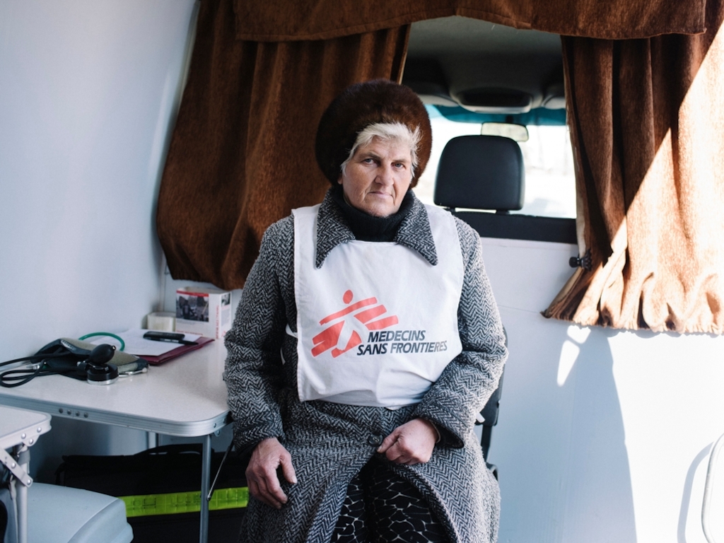 A volunteer MSF health worker sits in the back of a mobile medical clinic, run from a van, that serves the population of Mayorsk, Ukraine, near the frontline between government and opposition forces. Photographer: Christopher Nunn/MSF