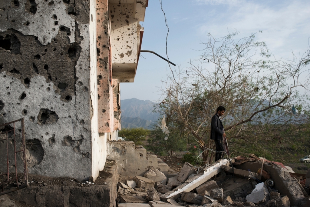 System identifier<br/>: MSF150894<br/>Title<br/>: MSF in Al Dhale and Taiz, Yemen. July 2015<br/>Photographer / cameraman<br/>: Alex Potter<br/>Countries:<br/>Yemen<br/>Description<br/>: A Yemeni man surveys the damage from an airstrike from the previous night on July 21,<br/>2015 in Qataba, Yemen. At least four missiles struck a cluster of houses outside Qataba, killing at least<br/>four people and injuring dozens, many of whom were brought to the MSF supported hospital in<br/>Qatab
