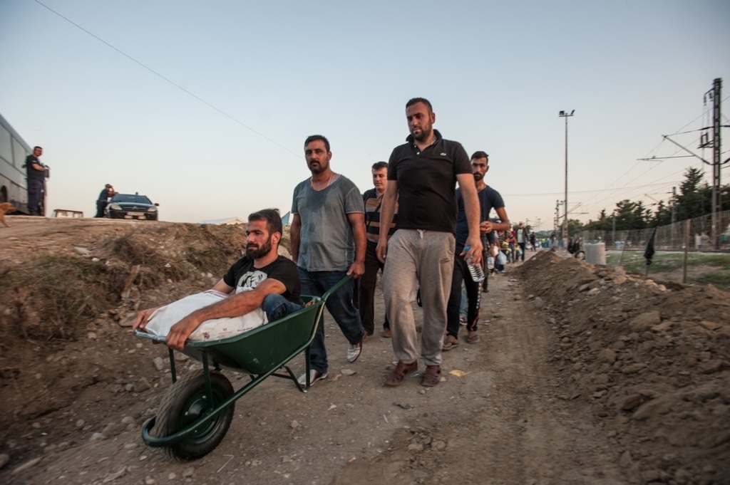 Photographer: Borja Ruiz Rodriguez<br/><br/>Caption: A disabled man crosses the border with his friends at Idomeni. He came to the border, carried on the back of one of his friends. He has no legs but was unable to bring his wheelchair on the boat with him when they came from Turkey to Greece.