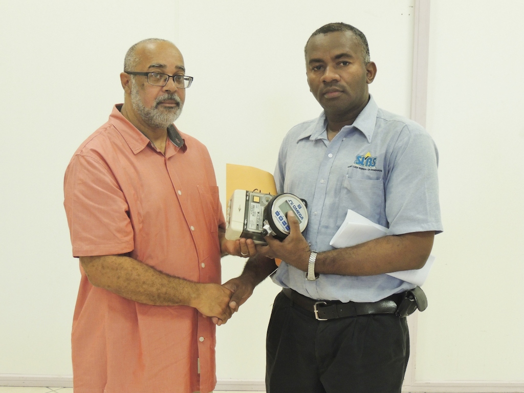 Mr. Gittens accepts equipment from OECS Director General - Dr. Didacus Jules