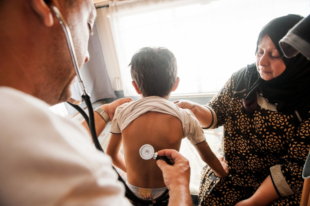Photographer: Georgios Makkas<br/><br/>Caption: Six year old Mohammed, together with his mother from Iraq is given a health check by the Doctors Without Borders (MSF) doctor Dimitris Giannousis at the mobile clinic in Mytiline port, Lesbos, Greece.
