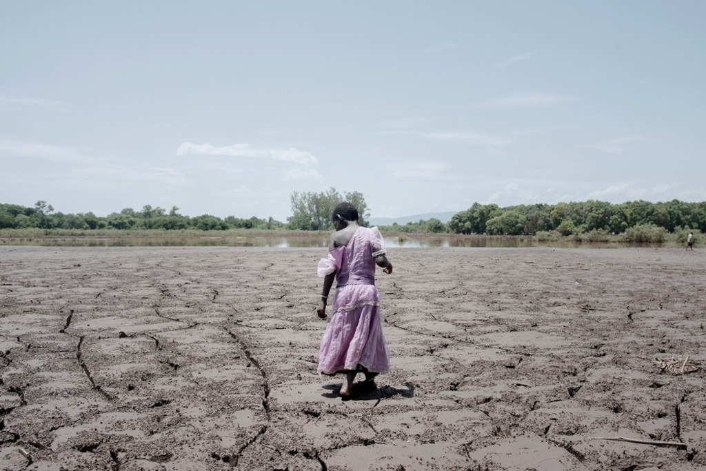 System identifier<br/>: MSF141951<br/>Title<br/>: Malawi floods, FEB 2015<br/>Photographer / cameraman<br/>: Luca Sola<br/>Countries:<br/>Malawi<br/>Description<br/>: Alesi Phiri, 7yo, walks on a former field as she looks to the thick coat of dried mud. 85%<br/>of the population in the area relies on agriculture for economic survival. Consequences of the floods<br/>will likely be felt for months as all crops have been destroyed.