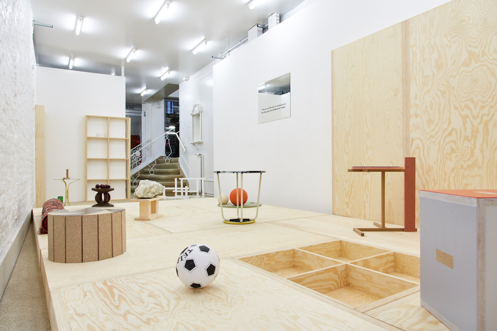 'Living Room' (carpet and objects that could function as a stool or a coffee table when they're not a sculpture) Hans Demeulenaere, en de spiegel 'If the Sun Were the Size of a Red Blood Cell, the Milky Way Would Be the Size of Canada' (text on mirror) Emi Kodama