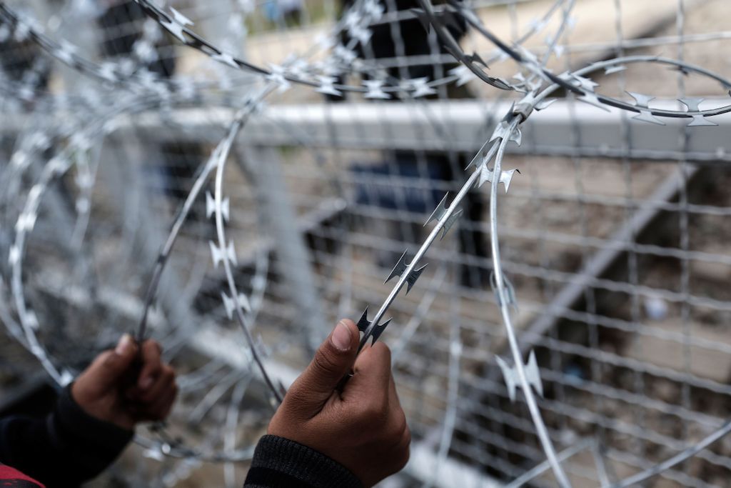 Konstantinos Tsakalidis/SOOC. An Afghan child holds the fence during protest at the Greek-Macedonian (FYROM) border near the northern Greek village of Idomeni.