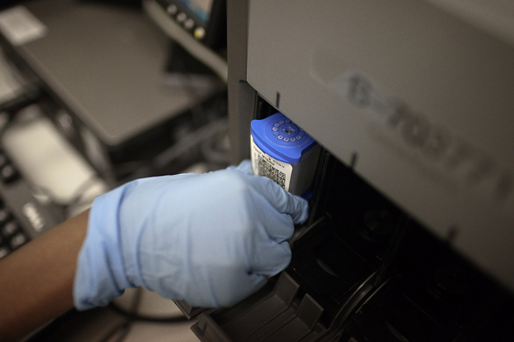 Medical officer Neisha Mohess, scans a sample of sputum for loading into an automated molecular TB diagnostic machine called GeneXpert. Photographer: Jose Cendon