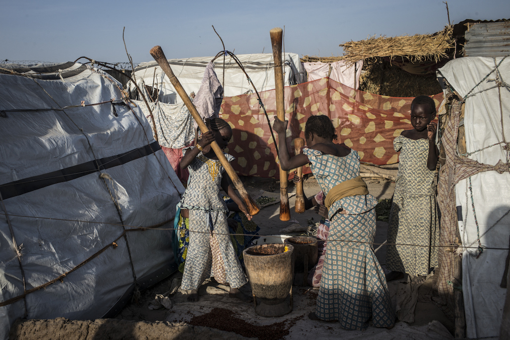 Chlidren pounding beans. Photographer: Sylvain Cherkaoui