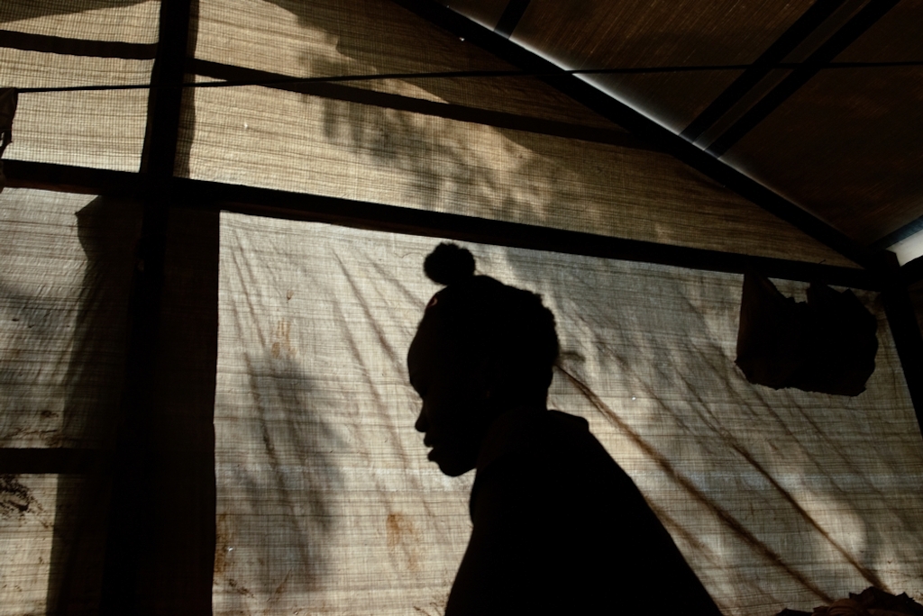 MSF159659<br/>Rebeka inside shelter at a displaced persons camp in Benzvi, Bangui.<br/><br/>Rebeka fled the violence in Kaga-Bandoro, a market town 245 km North of Bangui. Her house there was burned and looted by armed groups. After five days travelling from Kaga-Bandoro to Bangui, she arrived in BenZvi camp with her older brother and older sister. It's now been five months since moved to the camp. She does not work but cares for her sisters children: "The hardest thing for us is to find food. Sometimes we sleep without eating". Rebeka says she does not want to go back to Kaga-Bandoro, and wants to remain in the camp for more security.