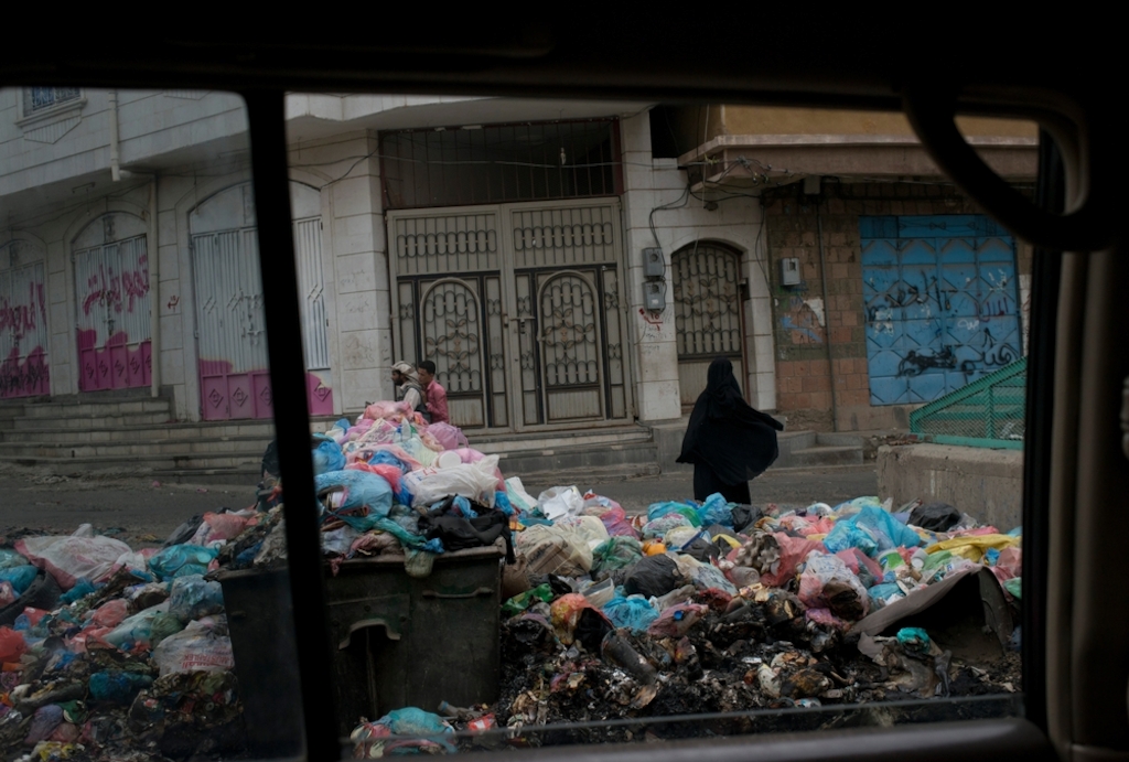 A Yemeni woman waks past garbage lining the streets on July 24, 2015 in<br/>Taiz, Yemen. Taiz has been the site of heavy<br/>fighting, and nearly all civil services have<br/>stopped.<br/>Credit: MSF