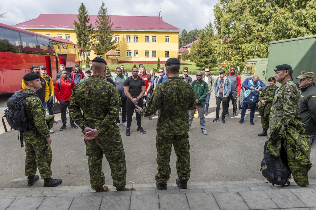 Des joueurs de la LCF rencontrent des militaires déployés dans le cadre de l'opération UNIFIER à Starychi, en Ukraine. Photo : CplC Mathieu Gaudreault, Caméra de combat des Forces canadiennes