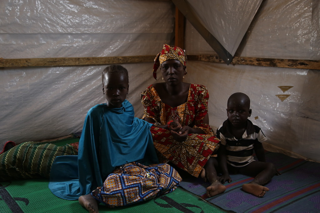 A mother with her two children at a camp for internally displaced people in the northeastern Nigerian town of Pulka. Photographer: Igor Barbero