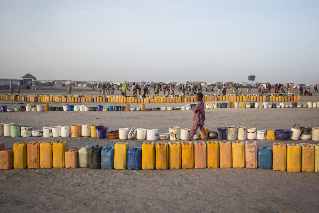 Every morning the camp residents rush to the water point to line up their buckets to be filled. Access to water is a major problem for the displaced. Photographer: Sylvain Cherkaoui