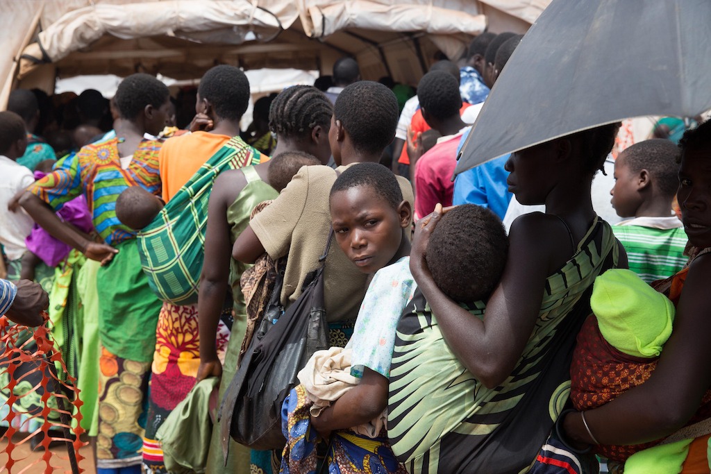 People queue outside a Doctors Without Borders (MSF) clinic. <br/><br/>Over 5.800 Mozambican nationals have camped in the village of Kapise 2 in Malawi after fleeing their homes in Mozambique, the majority of them women, children and the elderly. Half of the consultations in the MSF clinics are malaria cases. © James Oatway / MSF
