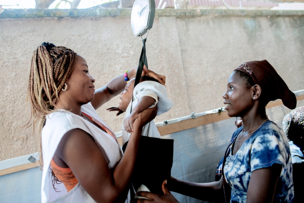 MSF159663<br/>17 year old Mireil has her baby weighed by a Medecins Sans Frontiers (MSF) staff member at an MSF hospital at a displaced persons camp in Benzvi, Bangui