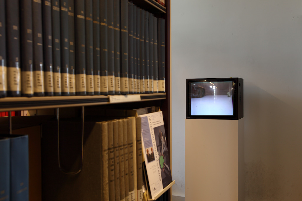 Installatiezicht 'Entre nous quelque chose se passe...' in de Bibliotheek Faculteit Rechtsgeleerdheid KU Leuven. <br/>Kunstenaar en werk: David Claerbout, Cat and bird in peace (1996)<br/>Foto © Dirk Pauwels
